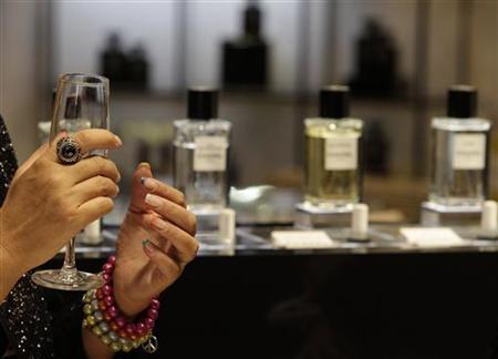 Woman gestures next to perfume display at KaDeWe luxury department shopping store in Berlin